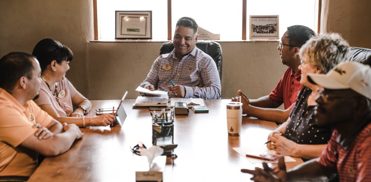 diverse group of people sitting at a table during meeting
