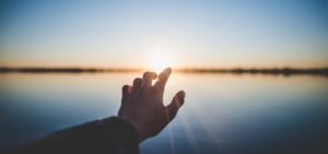 Hand stretched towards the sun