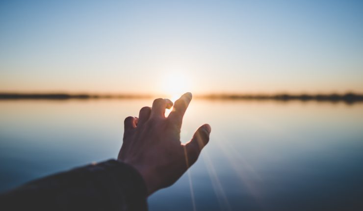 Hand stretched towards the sun