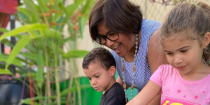 Woman watering plants with kids