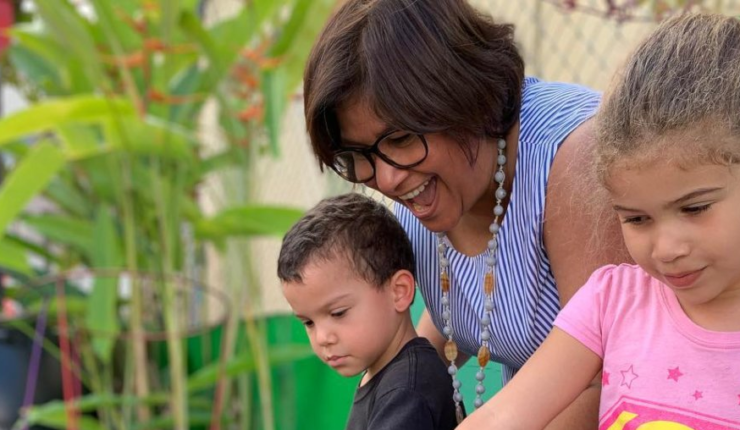 Woman watering plants with kids