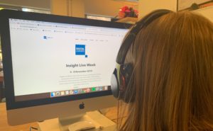 woman looking at computer screen wearing headphones