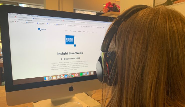 woman looking at computer screen wearing headphones