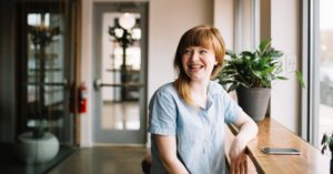 woman smiling next to phone