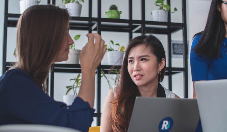 two people talking with laptop