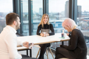 people sitting a table at work talking and laughing