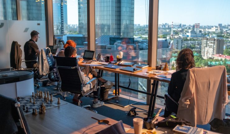 workplace - people sitting at desk up again window working