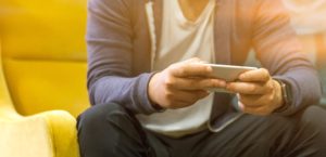 man sitting on chair with phone