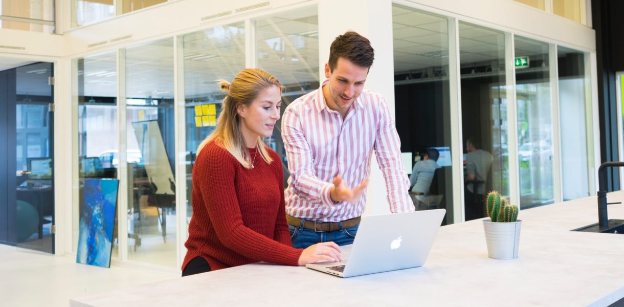 man and woman looking at computer