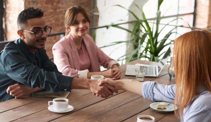 handshake between man and women in office
