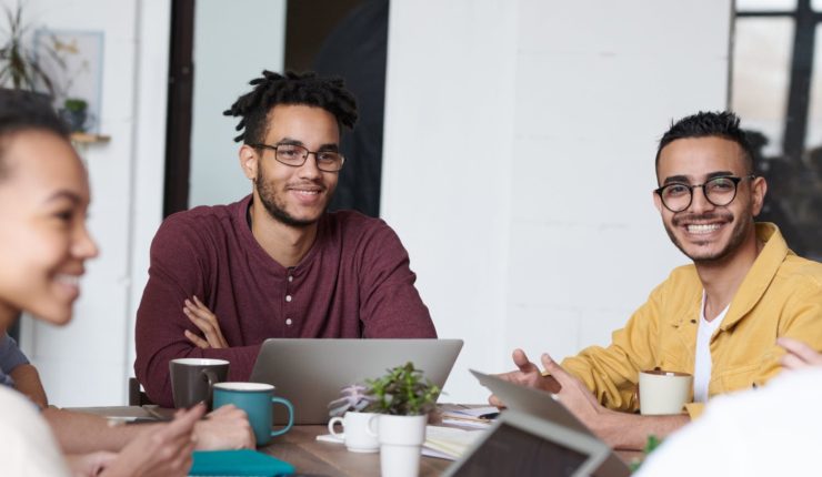 men and women sitting around table working