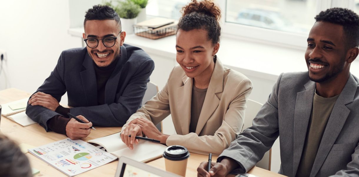 two men and one women sitting in meeting working