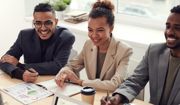 two men and one women sitting in meeting working