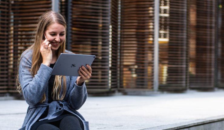 woman using ipad and speaking on phone