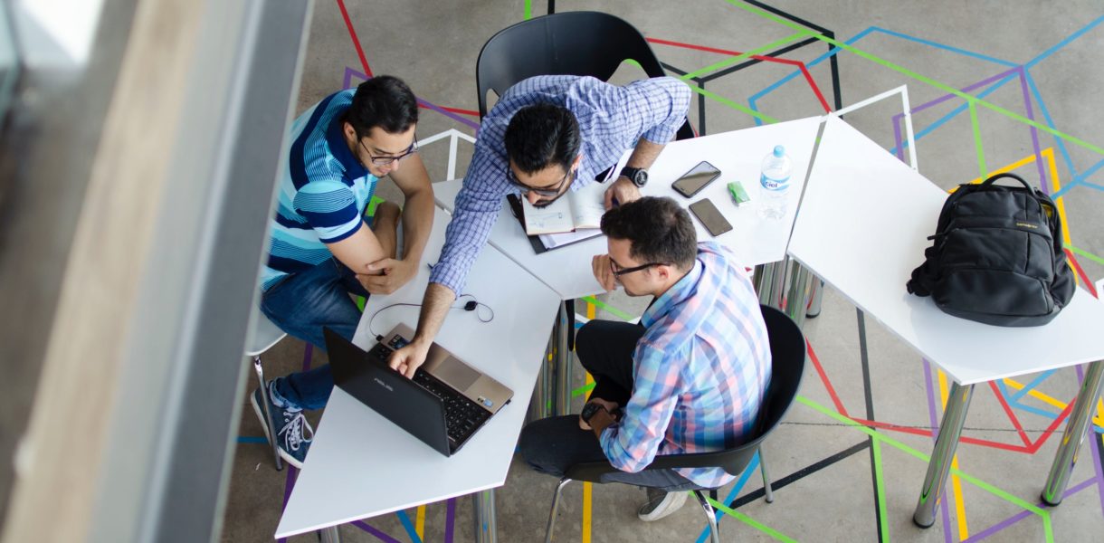 three guys working around a computer