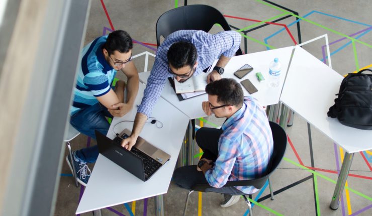 three guys working around a computer