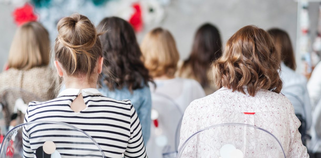 Teens siting in classroom with their back towards the camera