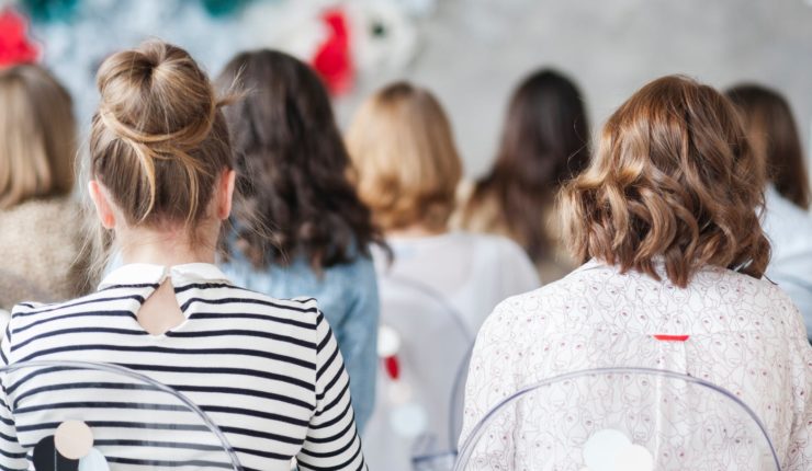 Teens siting in classroom with their back towards the camera