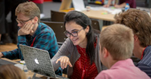 people sitting around table working on computer
