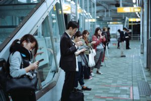 people on train platform on phones