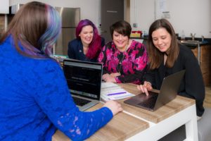 women around a meeting table