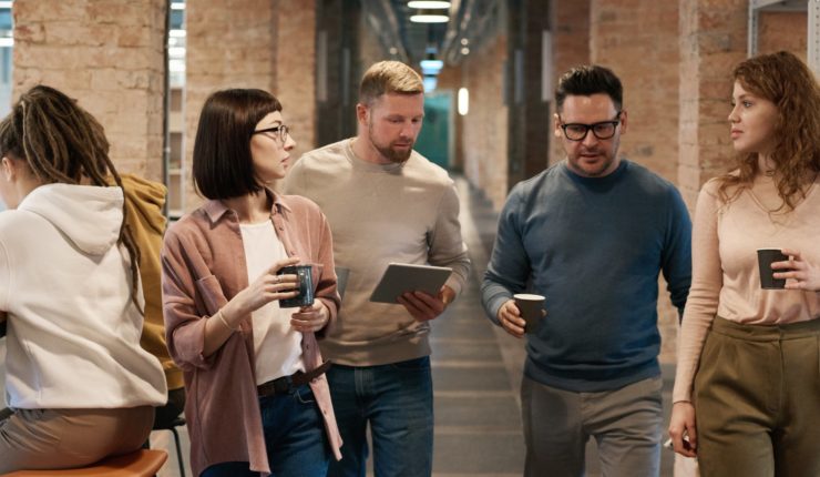 men and women walking in office