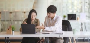 man and woman working on computer