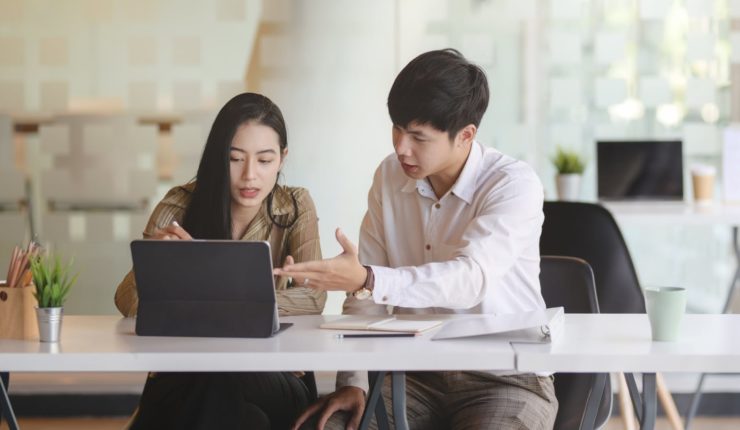man and woman working on computer