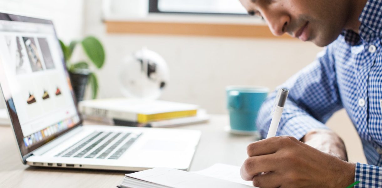man writing in notebook