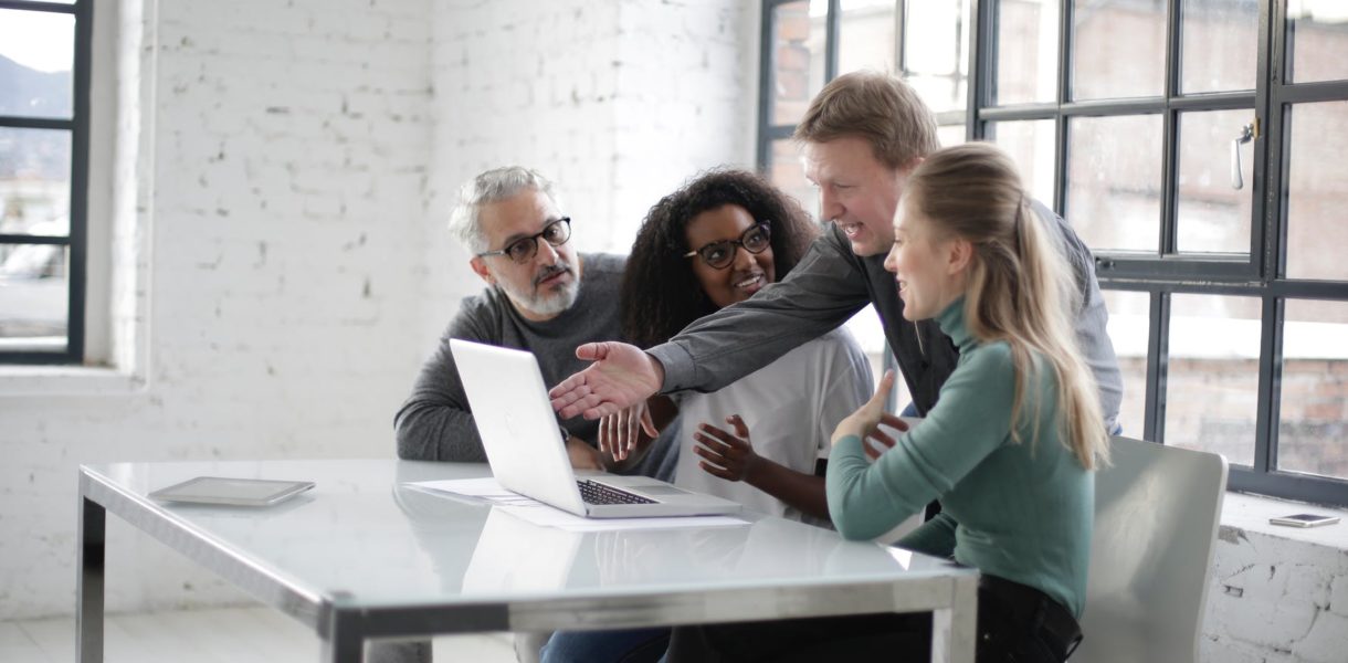 people sitting at table looking at computer