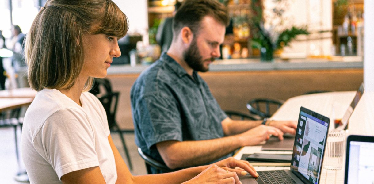 man and woman using computer