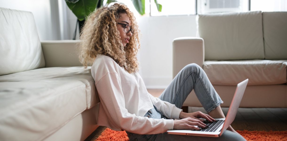woman sitting on the floor, working on computer