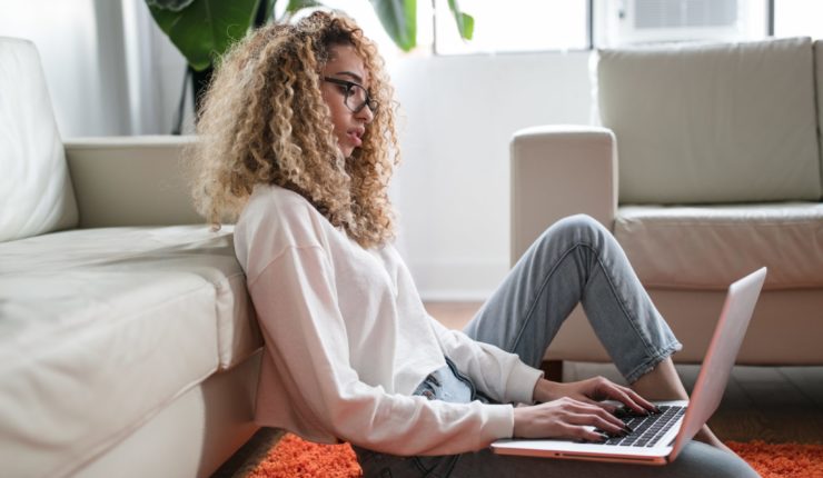 woman sitting on the floor, working on computer