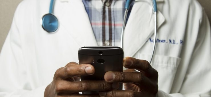 doctor typing on phone