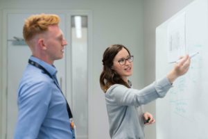 woman pointing at whiteboard