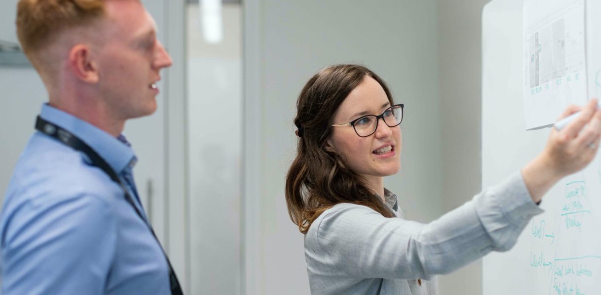 woman pointing at whiteboard