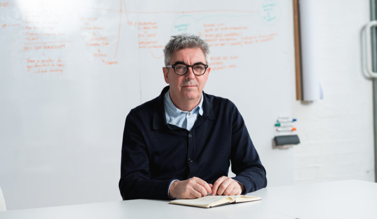 Man in black jumper sat at a desk