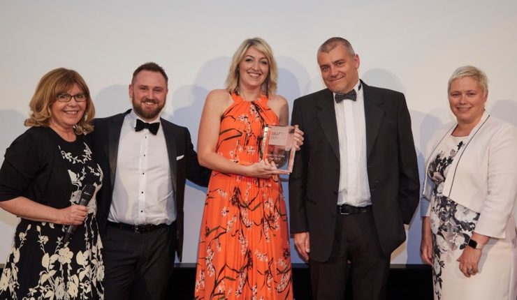 3 people posing after winning an award