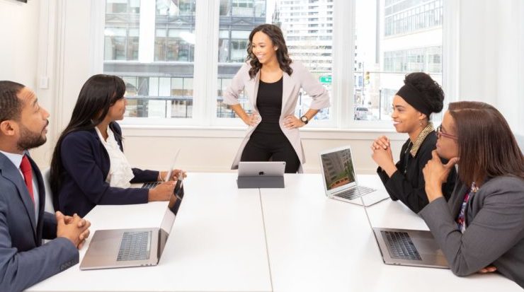 5 people in an office using laptops