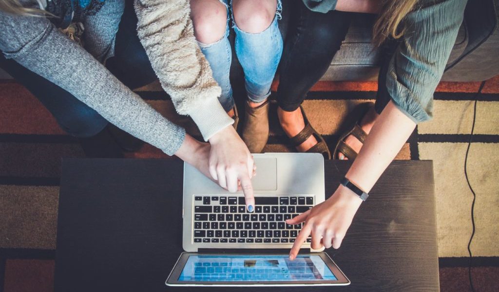 Group of hand pointing at a lap top