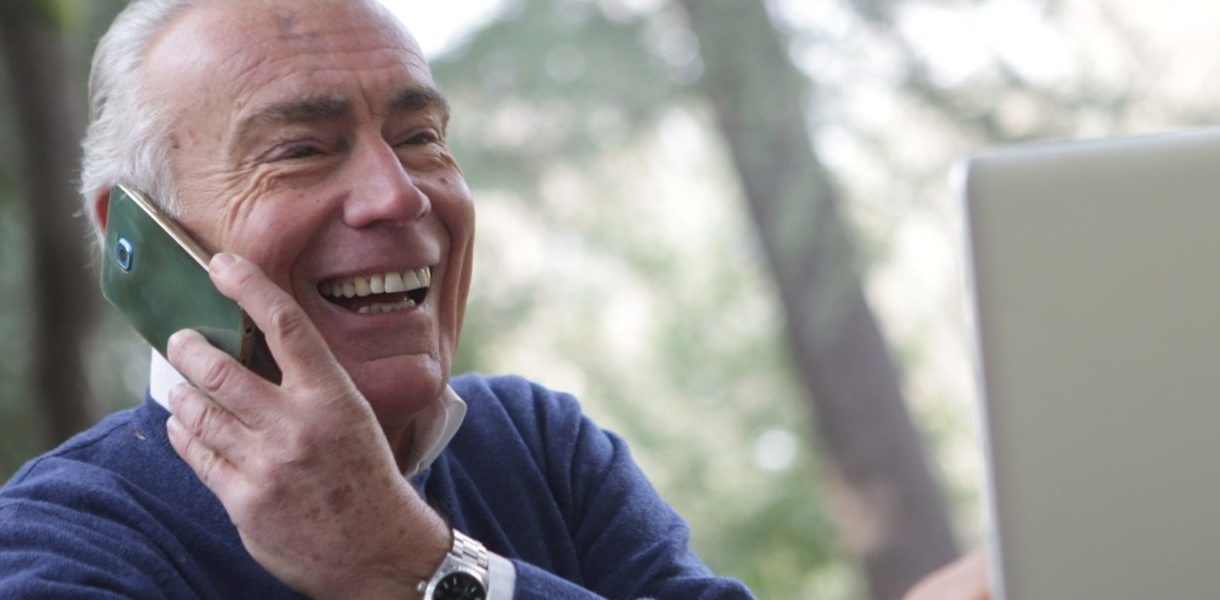 a man in wearing long sleeve shirt using a mobile phone