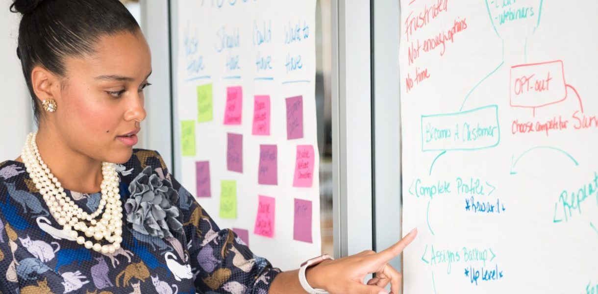 woman pointing at white board