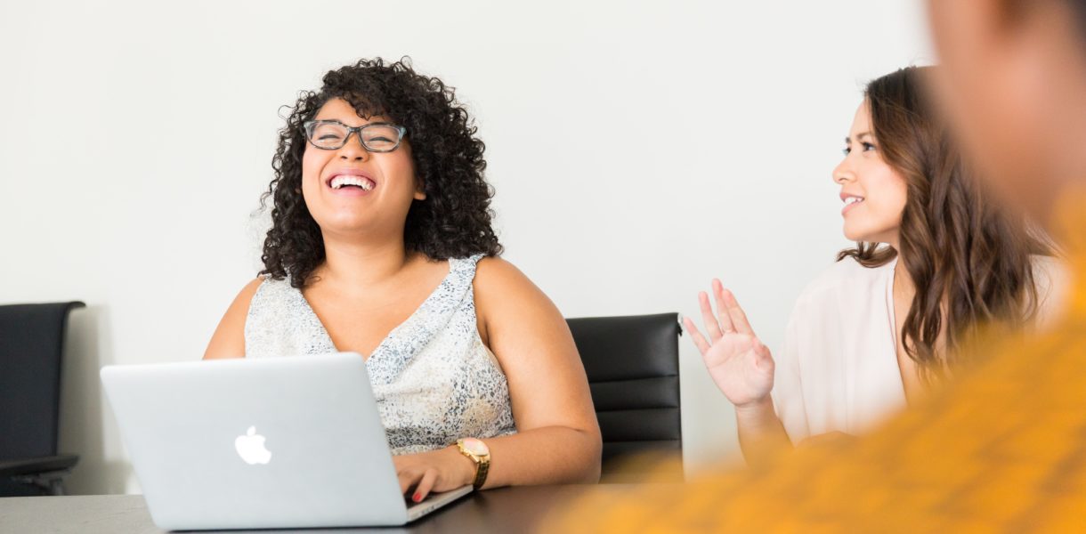 woman laughing at laptop