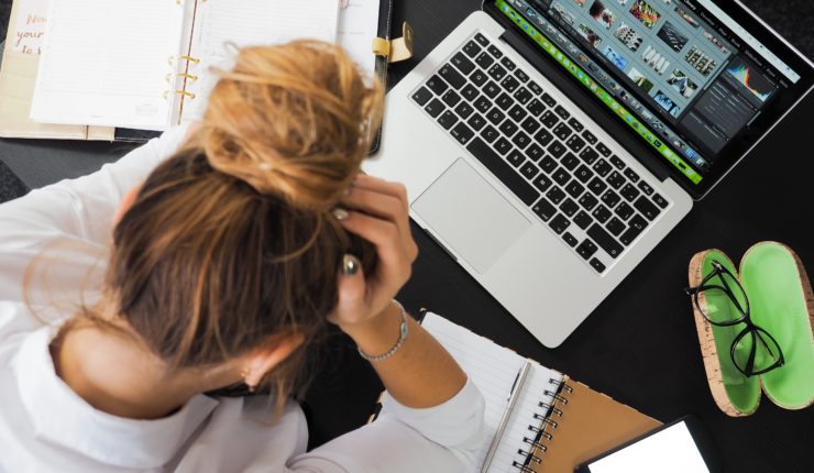 girl head in hands over her laptop