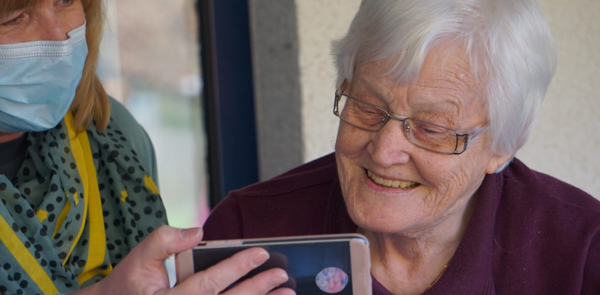 elderly woman looking at iphone