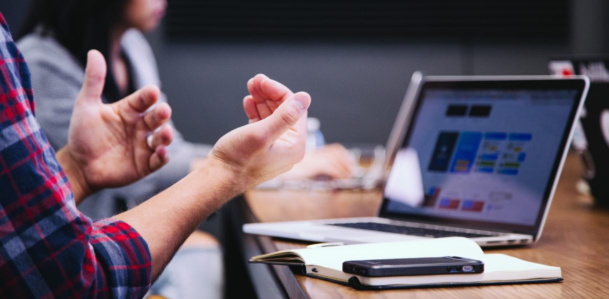 using hand gestures to explain somrthing on a laptop
