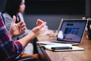 using hand gestures to explain somrthing on a laptop