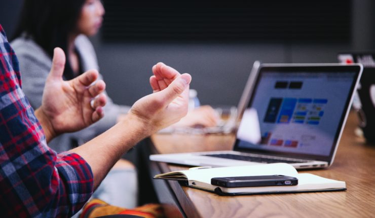 using hand gestures to explain somrthing on a laptop