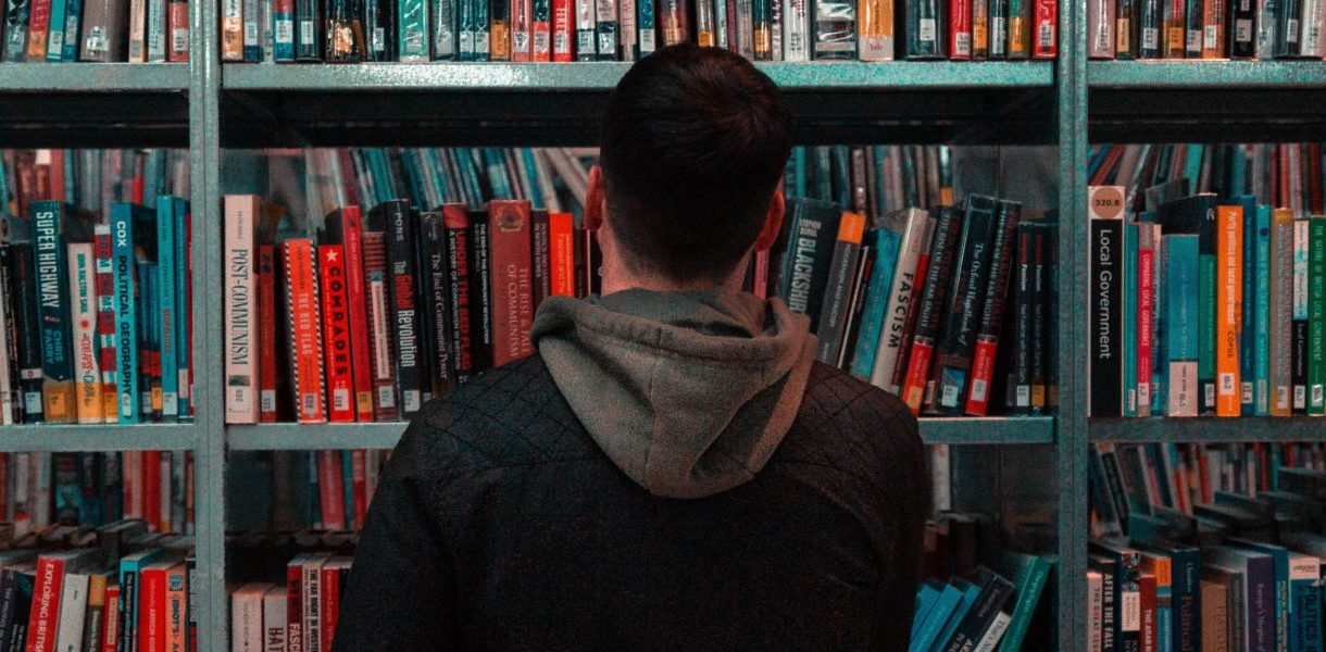 man looking at books