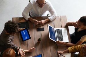 group of people at a table working on laptops